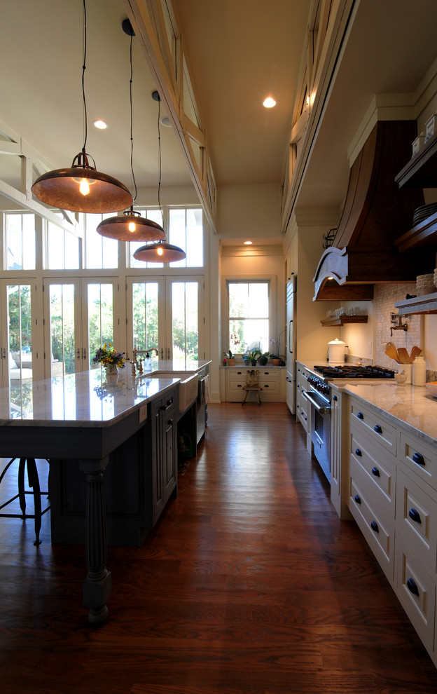 Inspiration for a craftsman galley dark wood floor open concept kitchen remodel in San Francisco with a farmhouse sink, shaker cabinets, beige cabinets, marble countertops, gray backsplash, stone tile backsplash, stainless steel appliances and an island