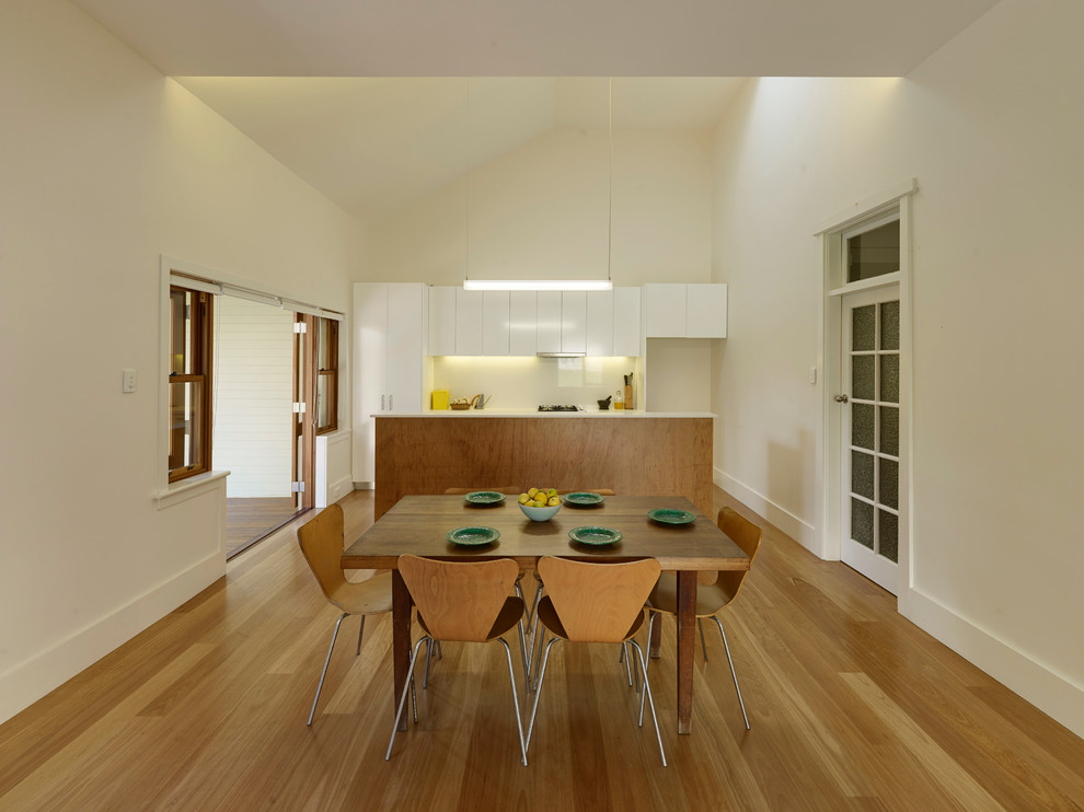 Foto di un'ampia sala da pranzo aperta verso il soggiorno moderna con pareti bianche e parquet chiaro