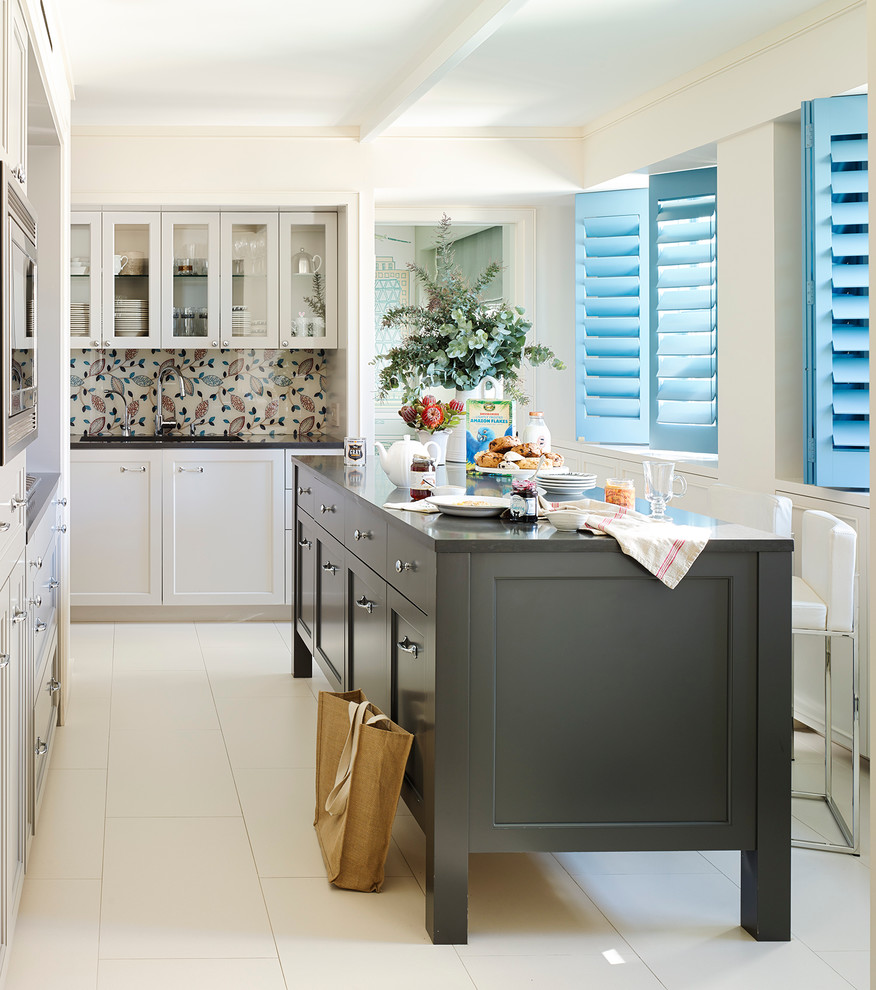 Стильный дизайн: кухня в стиле неоклассика (современная классика) с фасадами в стиле шейкер, белыми фасадами, разноцветным фартуком и островом - последний тренд