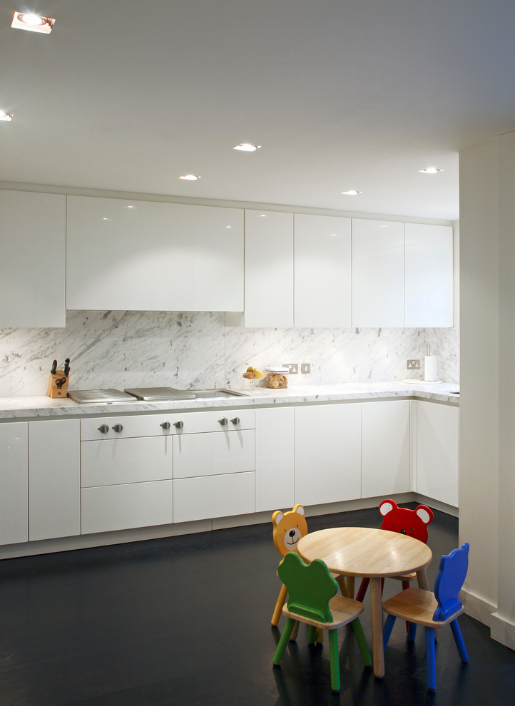 Photo of a contemporary kitchen in London with flat-panel cabinets, white cabinets, white splashback and marble splashback.