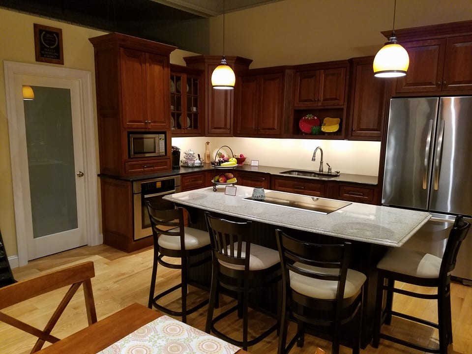 Zweizeilige, Mittelgroße Moderne Küche mit Vorratsschrank, Unterbauwaschbecken, profilierten Schrankfronten, dunklen Holzschränken, Granit-Arbeitsplatte, Küchenrückwand in Weiß, Küchengeräten aus Edelstahl, hellem Holzboden, zwei Kücheninseln und gelbem Boden in Boston