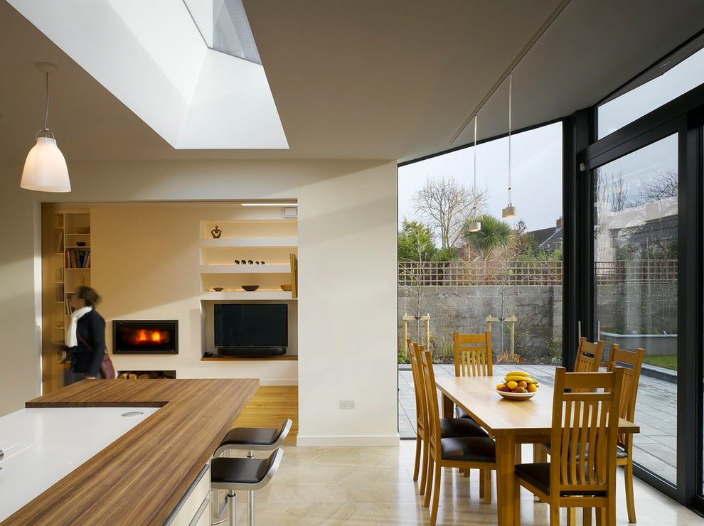 На фото: кухня в стиле модернизм с деревянной столешницей и обеденным столом с