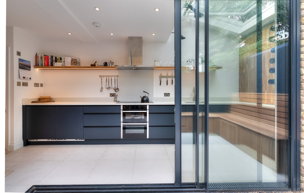 Foto på ett litet funkis grå kök, med släta luckor, blå skåp, bänkskiva i koppar, grått stänkskydd, klinkergolv i keramik och grått golv