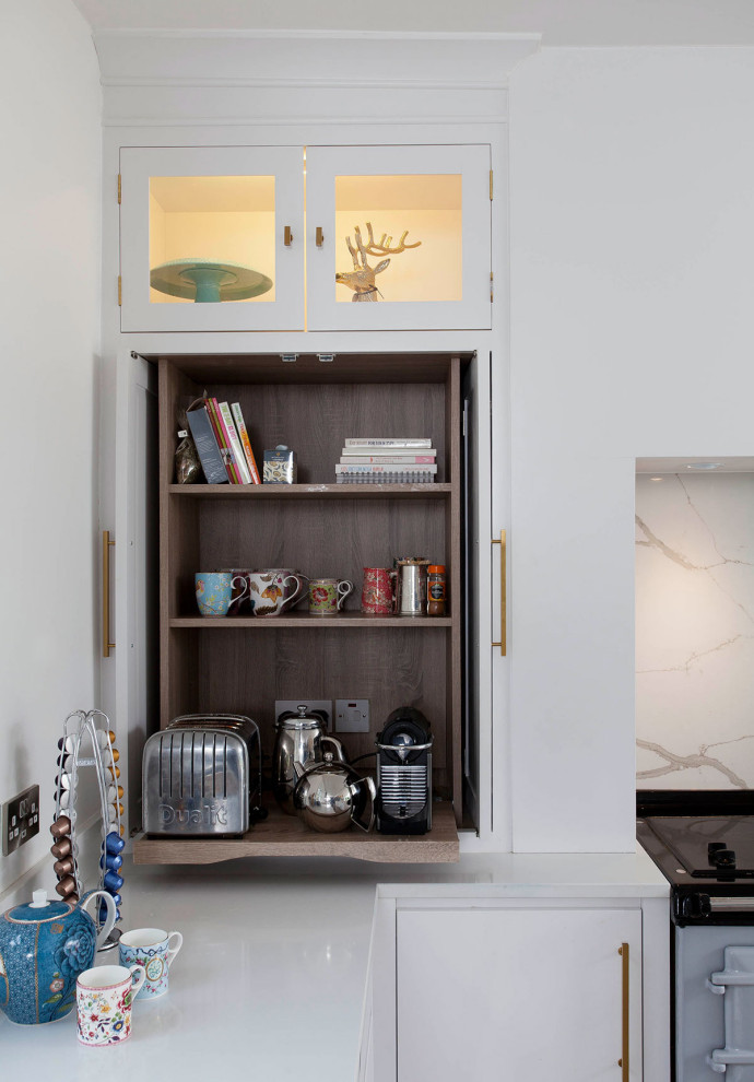 Imagen de cocina contemporánea con armarios con paneles lisos, puertas de armario blancas, salpicadero blanco, salpicadero de losas de piedra y encimeras blancas