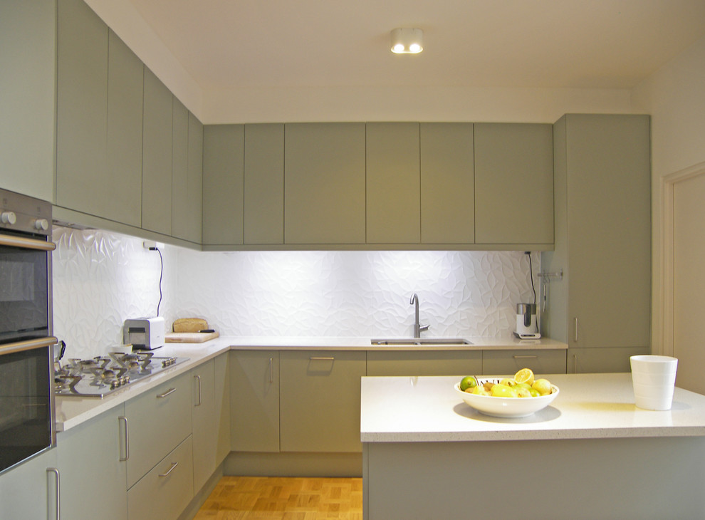 Example of a minimalist medium tone wood floor kitchen design in Other with flat-panel cabinets, gray cabinets, quartzite countertops, white backsplash and porcelain backsplash