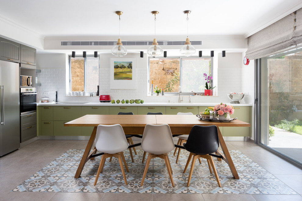 Inspiration for a cottage single-wall multicolored floor eat-in kitchen remodel in Other with flat-panel cabinets, gray cabinets, white backsplash, subway tile backsplash, stainless steel appliances and no island