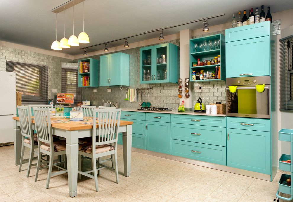 Ejemplo de cocina bohemia con puertas de armario azules y salpicadero de azulejos tipo metro