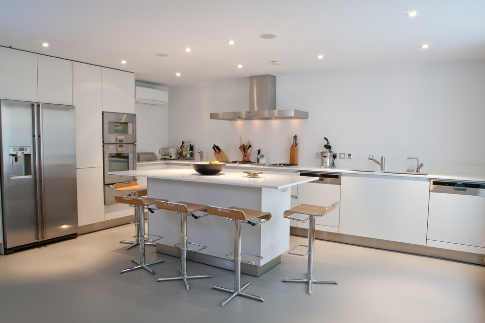 Esempio di una cucina minimalista con ante lisce, ante bianche, paraspruzzi bianco e elettrodomestici in acciaio inossidabile