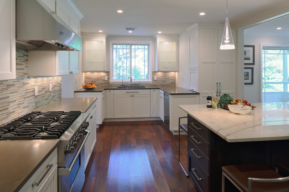 Mid-sized trendy u-shaped medium tone wood floor eat-in kitchen photo in New York with an undermount sink, shaker cabinets, white cabinets, granite countertops, white backsplash, glass tile backsplash, stainless steel appliances and an island