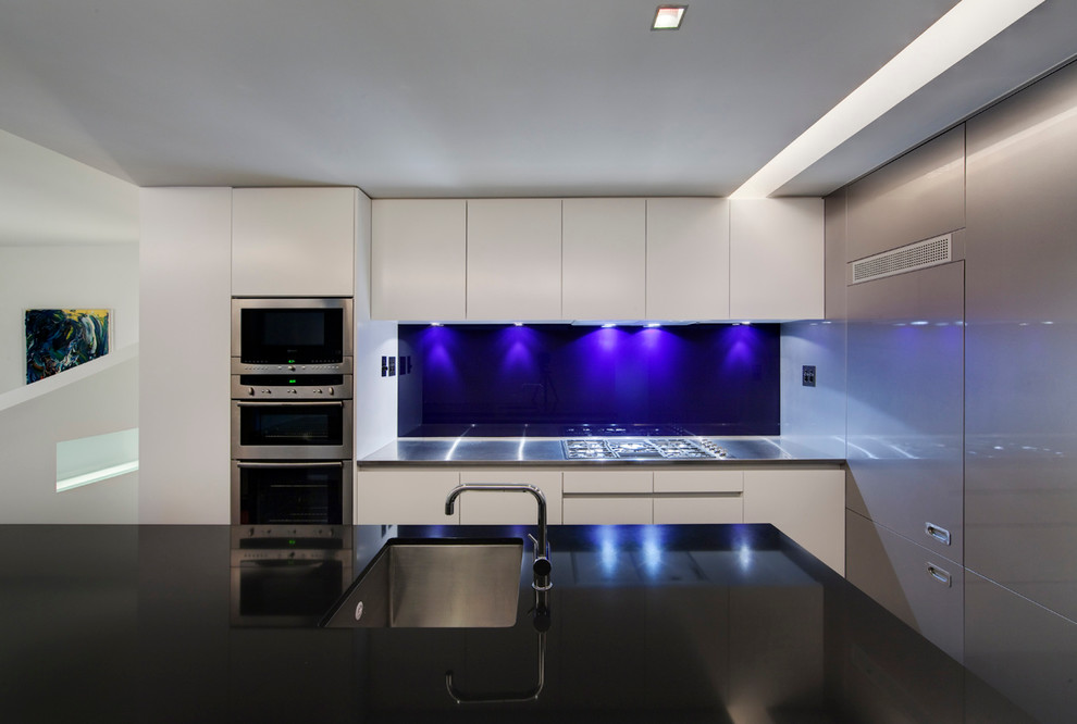 Foto di una cucina moderna di medie dimensioni con elettrodomestici in acciaio inossidabile e parquet scuro