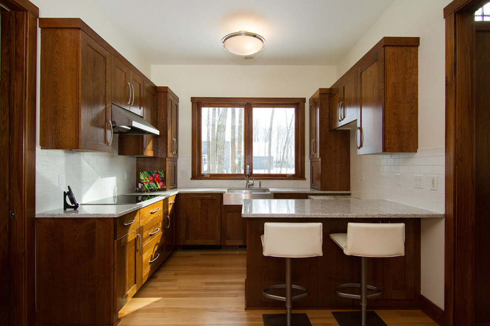 Bild på ett mellanstort vintage kök, med en undermonterad diskho, skåp i shakerstil, skåp i mellenmörkt trä, granitbänkskiva, flerfärgad stänkskydd, stänkskydd i mosaik, rostfria vitvaror, ljust trägolv och flera köksöar