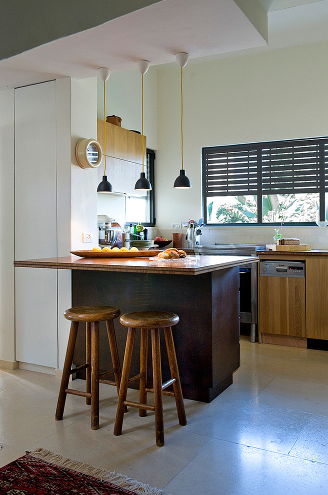 Foto de cocina bohemia con armarios con paneles lisos, puertas de armario de madera clara, salpicadero de azulejos tipo metro y electrodomésticos de acero inoxidable