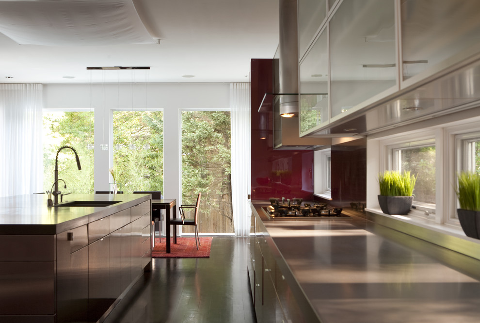 Large traditional l-shaped kitchen/diner in DC Metro with a submerged sink, flat-panel cabinets, red cabinets, concrete worktops, stainless steel appliances, dark hardwood flooring, an island, black floors and grey worktops.
