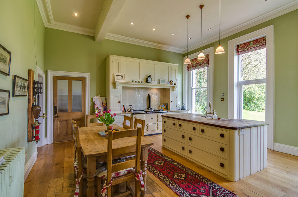 Klassische Küche mit Landhausspüle, Arbeitsplatte aus Holz, Küchenrückwand in Beige und Kücheninsel in Belfast