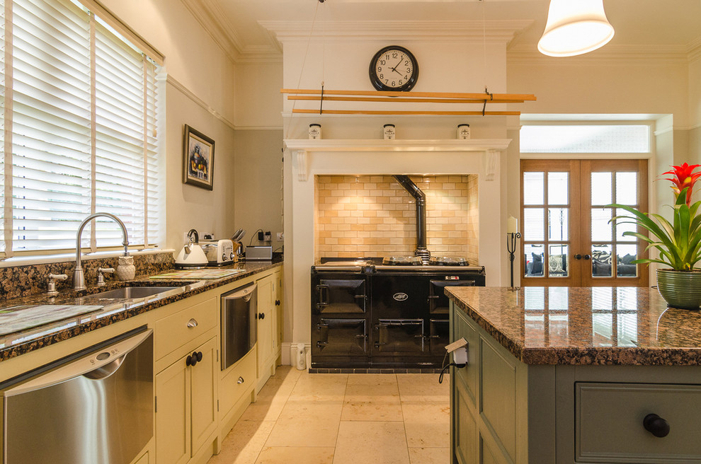 Klassische Küche mit Unterbauwaschbecken, beigen Schränken, schwarzen Elektrogeräten, Kücheninsel, Küchenrückwand in Beige und Rückwand aus Metrofliesen in Belfast