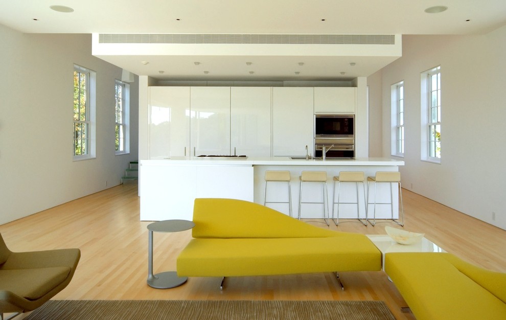 Example of a trendy galley open concept kitchen design in Portland Maine with flat-panel cabinets, white cabinets and stainless steel appliances