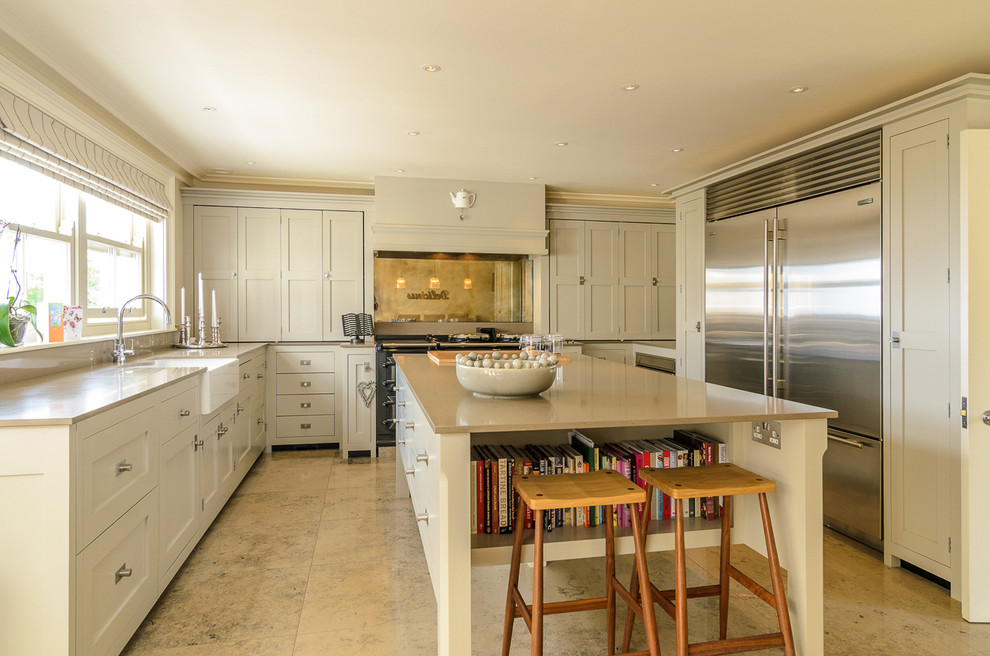 Foto de cocina tradicional con fregadero sobremueble, armarios estilo shaker, puertas de armario beige, electrodomésticos de acero inoxidable y una isla