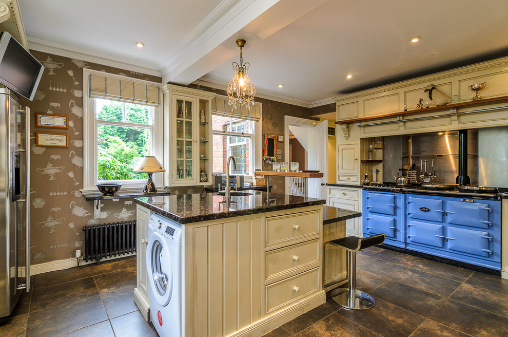 Photo of a large farmhouse u-shaped enclosed kitchen in Belfast with a submerged sink, recessed-panel cabinets, beige cabinets, metallic splashback, coloured appliances and an island.