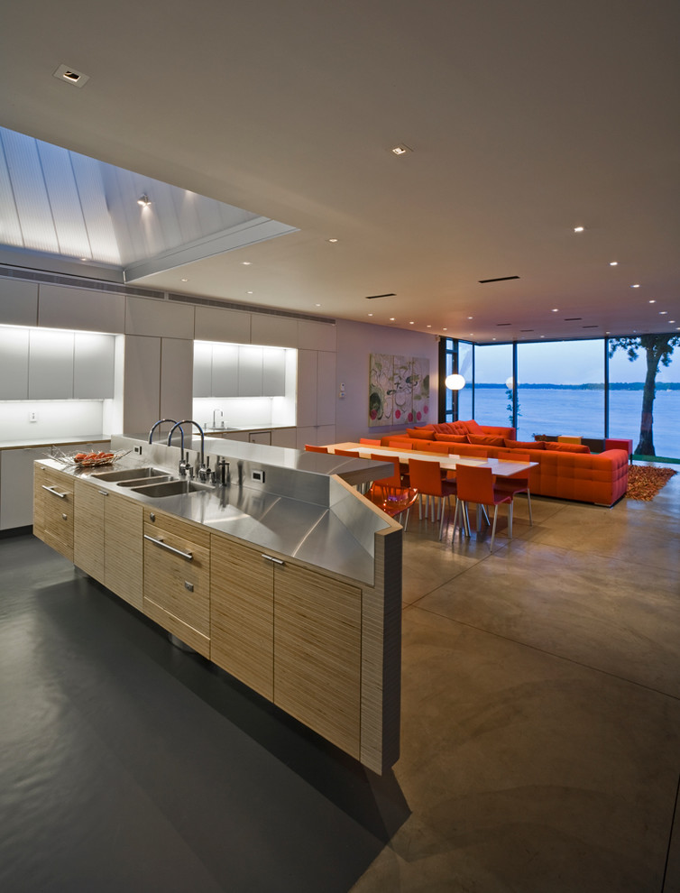 Источник вдохновения для домашнего уюта: кухня-гостиная в стиле модернизм с столешницей из нержавеющей стали, тройной мойкой, плоскими фасадами и светлыми деревянными фасадами