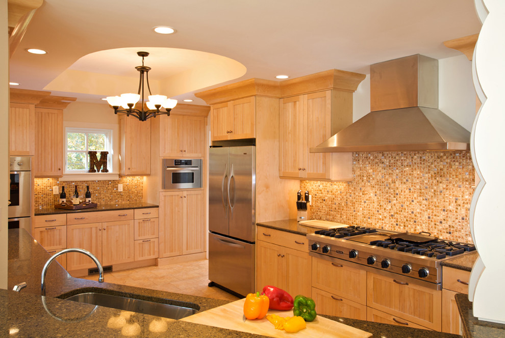 Diseño de cocina costera con puertas de armario de madera clara y electrodomésticos de acero inoxidable