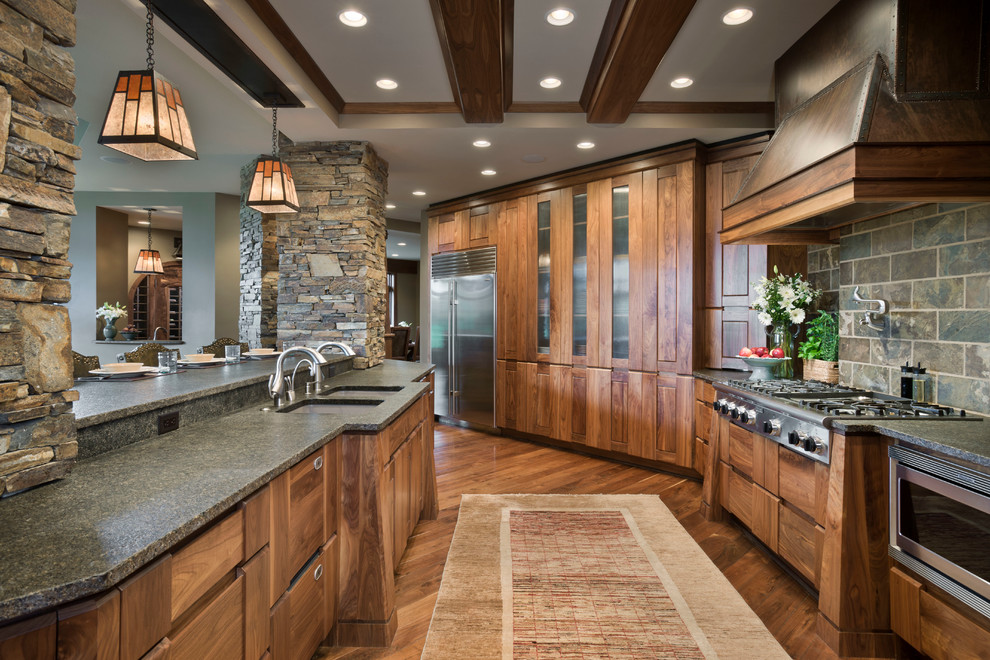 This is an example of a rustic kitchen in Other with a double-bowl sink, medium wood cabinets, multi-coloured splashback, stainless steel appliances, dark hardwood flooring and an island.