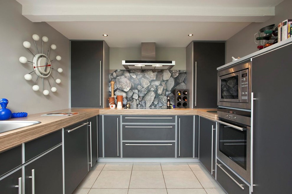 Geschlossene Moderne Küche in U-Form mit Einbauwaschbecken, flächenbündigen Schrankfronten, grauen Schränken, Küchengeräten aus Edelstahl und Laminat-Arbeitsplatte in Belfast