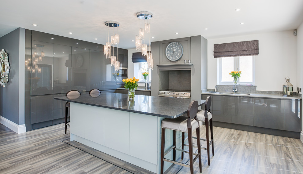 Medium sized classic l-shaped kitchen in Essex with a double-bowl sink, flat-panel cabinets, grey cabinets, an island, grey floors, grey worktops and stainless steel appliances.