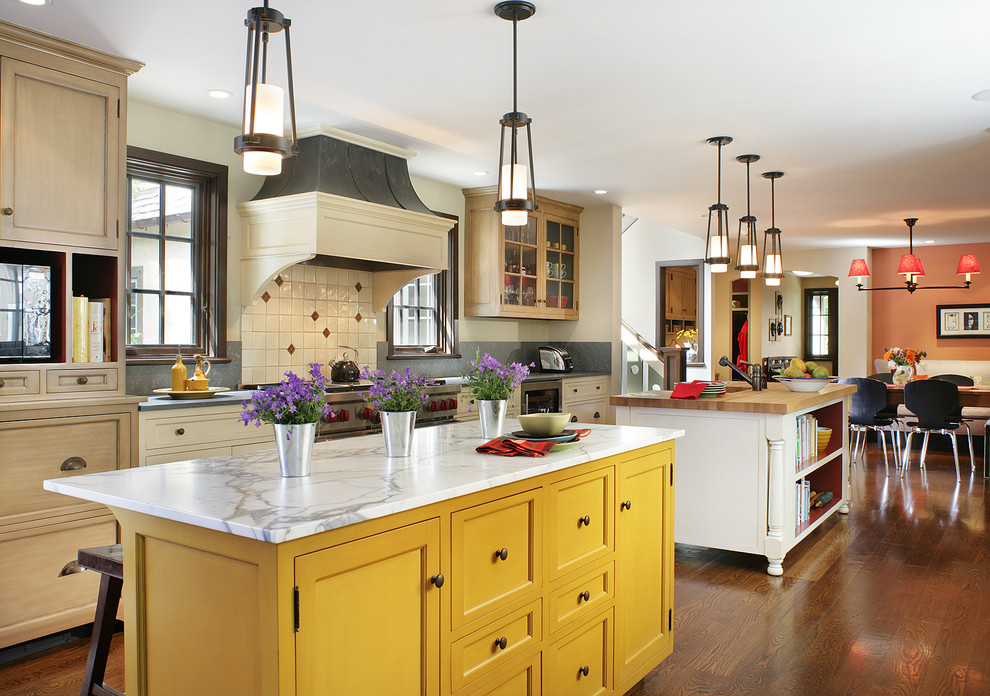 Imagen de cocina comedor tradicional con armarios estilo shaker, puertas de armario amarillas, salpicadero blanco y electrodomésticos de acero inoxidable