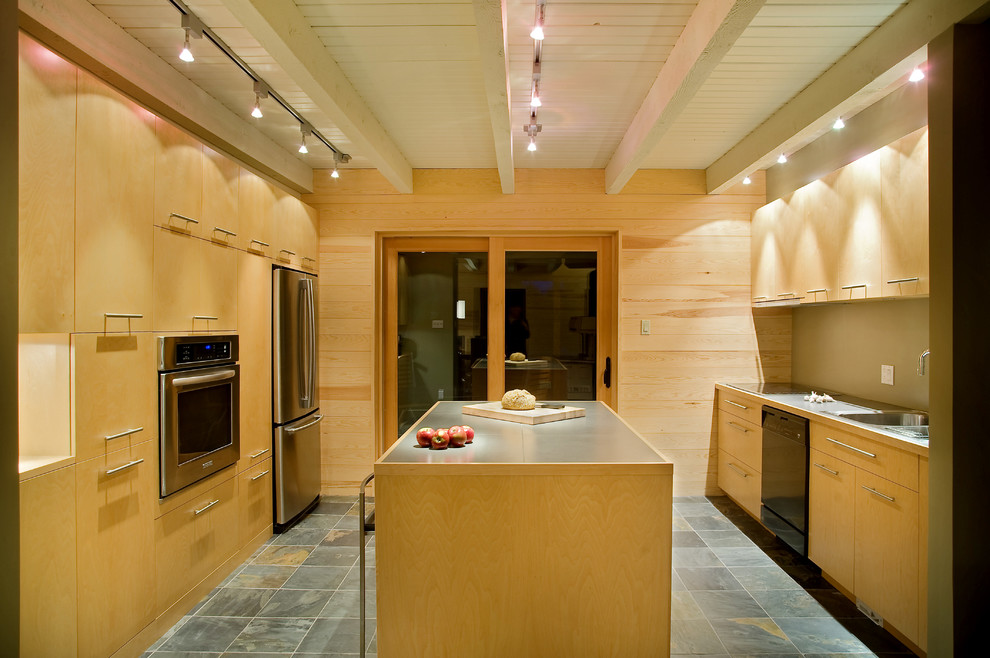 Photo of a contemporary kitchen in Montreal with a double-bowl sink, flat-panel cabinets, light wood cabinets, stainless steel appliances, slate flooring and an island.