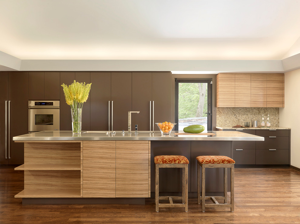 Diseño de cocina contemporánea con fregadero integrado, armarios con paneles lisos, puertas de armario marrones y electrodomésticos de acero inoxidable