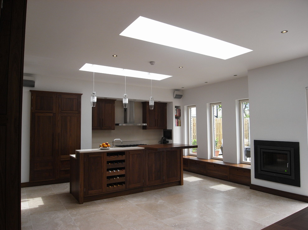 Foto di una cucina minimalista con ante in stile shaker, ante in legno bruno, top in quarzo composito, paraspruzzi beige e pavimento in travertino