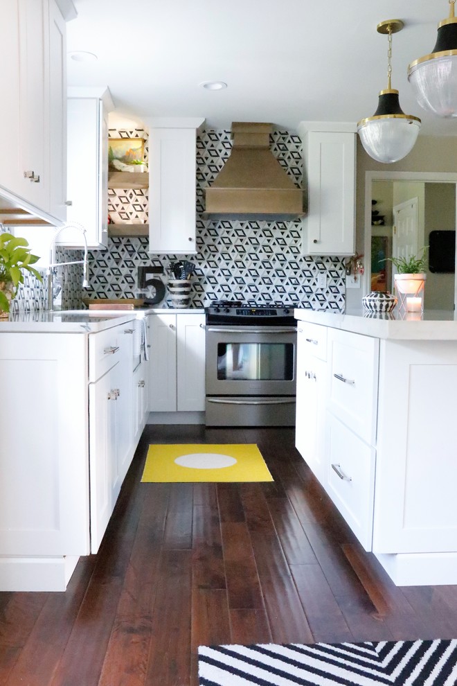 Inspiration for a medium sized eclectic l-shaped enclosed kitchen in St Louis with a belfast sink, shaker cabinets, white cabinets, marble worktops, multi-coloured splashback, ceramic splashback, stainless steel appliances, dark hardwood flooring, an island, brown floors and white worktops.