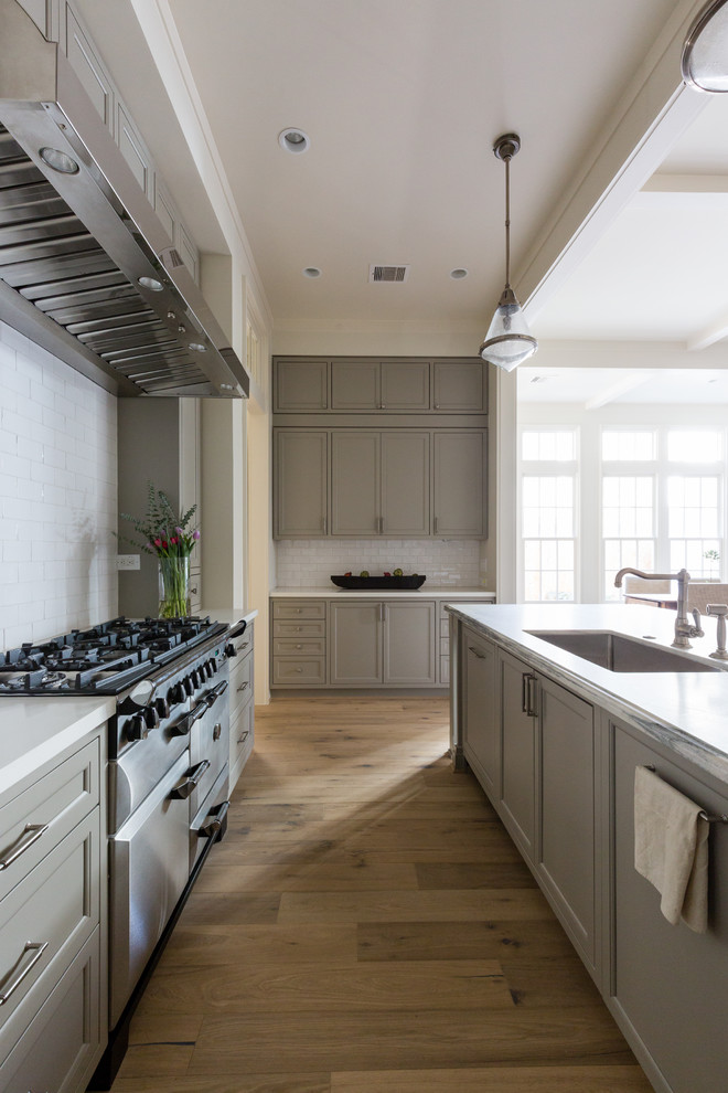 Ejemplo de cocina contemporánea grande abierta con salpicadero blanco, electrodomésticos de acero inoxidable y una isla