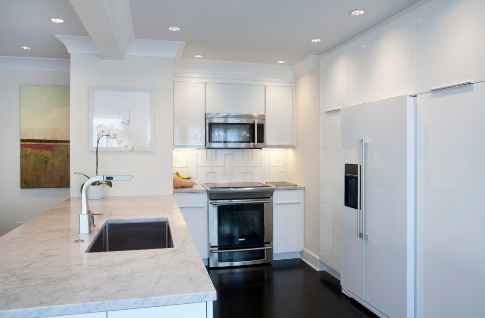 Design ideas for a small contemporary u-shaped open plan kitchen in Atlanta with a submerged sink, glass-front cabinets, white cabinets, marble worktops, white splashback, porcelain splashback, white appliances, dark hardwood flooring and a breakfast bar.