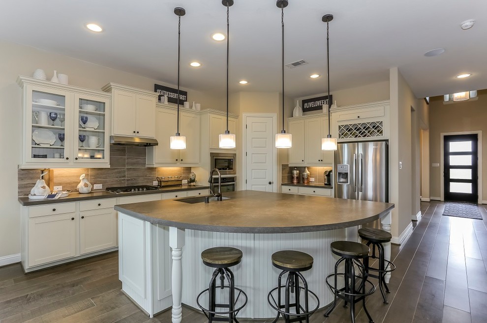 Eat-in kitchen - large farmhouse l-shaped medium tone wood floor and brown floor eat-in kitchen idea in Other with a double-bowl sink, recessed-panel cabinets, white cabinets, concrete countertops, gray backsplash, porcelain backsplash, stainless steel appliances and an island