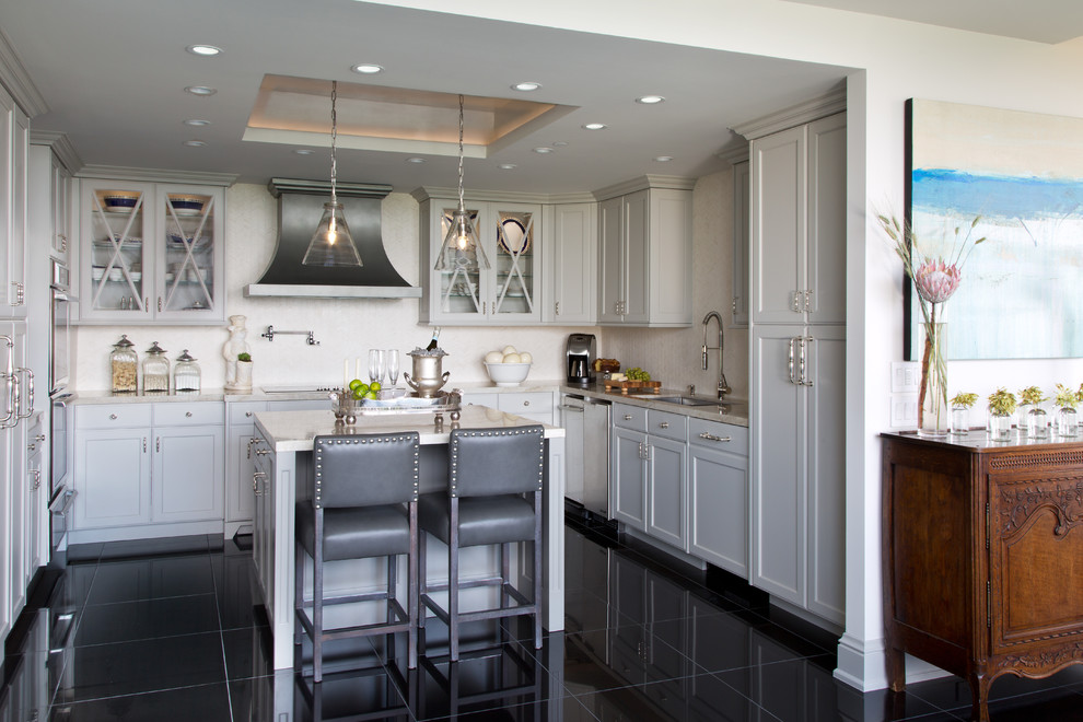 Classic grey and cream u-shaped kitchen in Houston with glass-front cabinets, beige splashback, an island, a single-bowl sink and grey cabinets.
