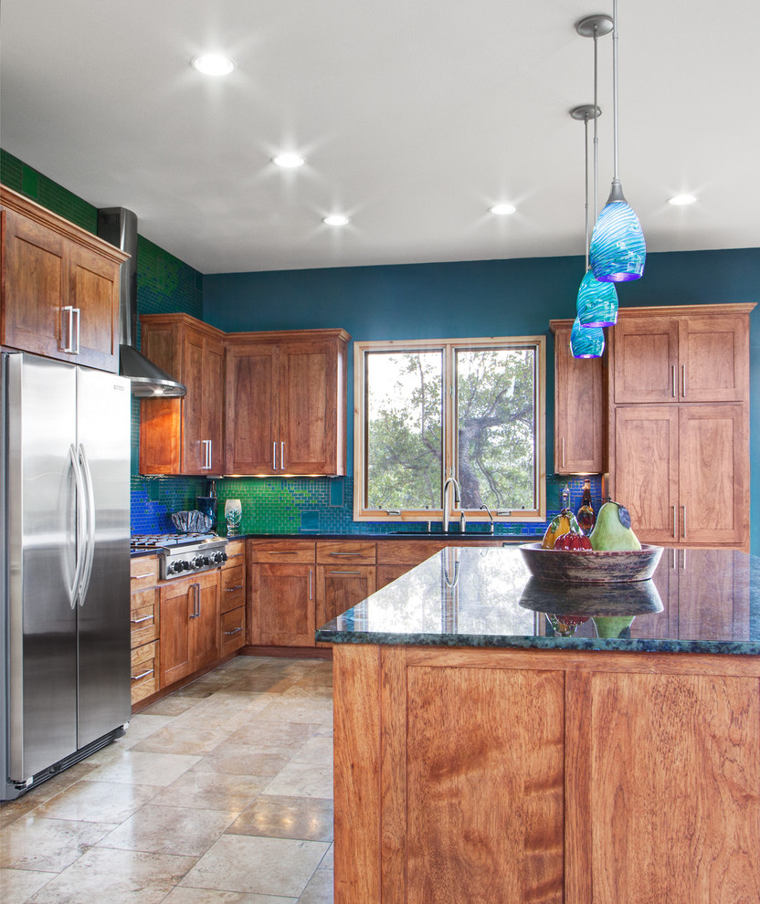 Moderne Küche in U-Form mit hellbraunen Holzschränken, Granit-Arbeitsplatte, Küchenrückwand in Blau, Rückwand aus Glasfliesen, Küchengeräten aus Edelstahl, Kücheninsel und blauer Arbeitsplatte in Austin