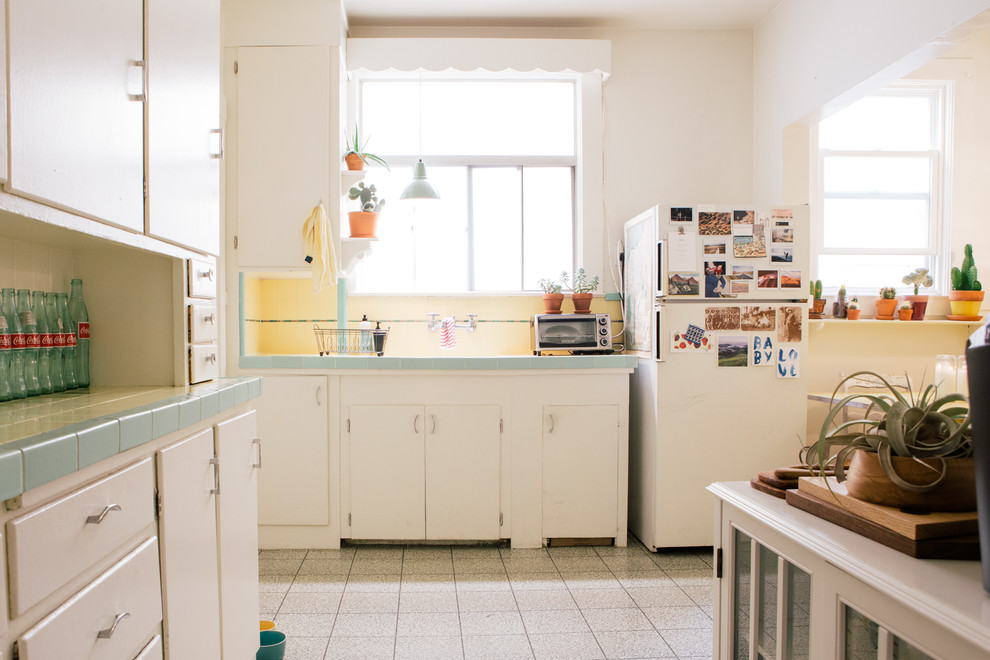 Источник вдохновения для домашнего уюта: маленькая кухня в стиле фьюжн с столешницей из плитки, белой техникой, полом из линолеума, плоскими фасадами, белыми фасадами и желтым фартуком для на участке и в саду