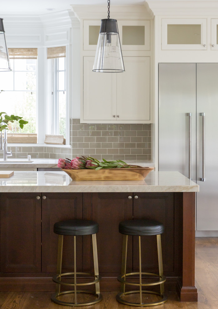 Inspiration for a transitional galley medium tone wood floor and brown floor kitchen remodel in San Francisco with an undermount sink, beaded inset cabinets, beige cabinets, beige backsplash, subway tile backsplash, stainless steel appliances, an island and beige countertops