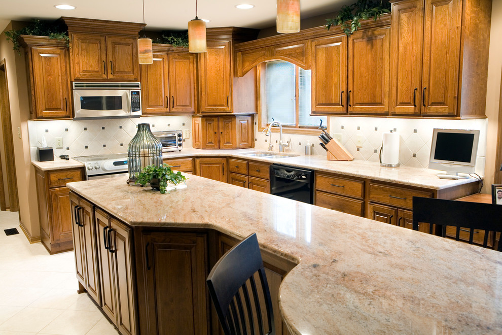 Arts and crafts l-shaped eat-in kitchen photo in Phoenix with an undermount sink, raised-panel cabinets, medium tone wood cabinets, white backsplash, ceramic backsplash and stainless steel appliances