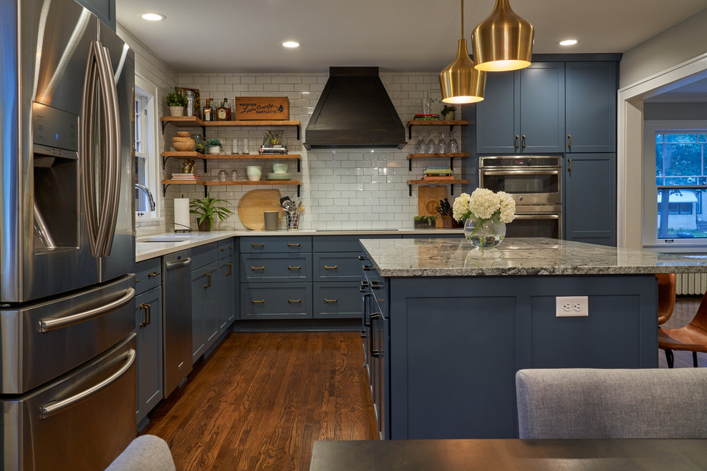 Large cottage l-shaped medium tone wood floor and brown floor eat-in kitchen photo in Minneapolis with an undermount sink, shaker cabinets, blue cabinets, granite countertops, white backsplash, subway tile backsplash, stainless steel appliances, an island and gray countertops