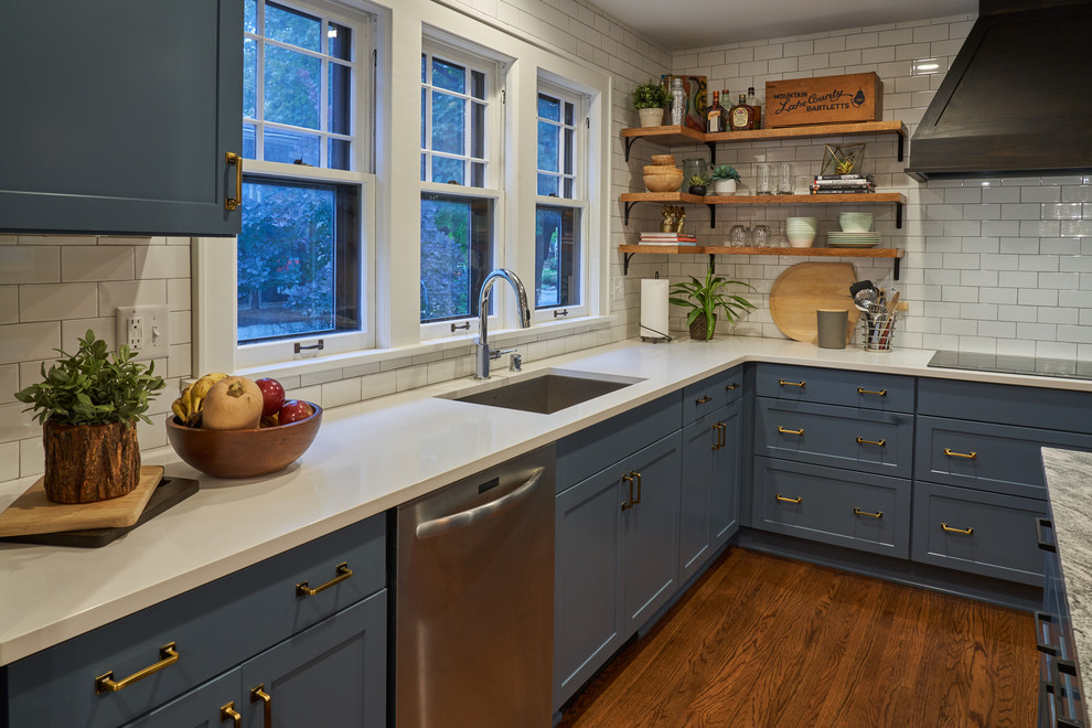 Large country l-shaped medium tone wood floor and brown floor eat-in kitchen photo in Minneapolis with an undermount sink, shaker cabinets, blue cabinets, granite countertops, white backsplash, subway tile backsplash, stainless steel appliances, an island and gray countertops