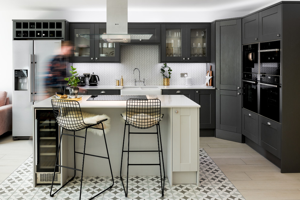 Inspiration for a medium sized classic kitchen in Hampshire with black cabinets, granite worktops, white splashback, ceramic splashback, porcelain flooring, an island, white worktops, a belfast sink, glass-front cabinets, stainless steel appliances and multi-coloured floors.