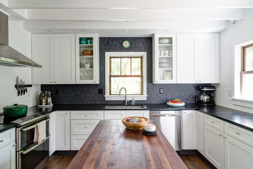 Premium RTA cabinets Canada — white shaker kitchen with glass-front uppers, dark mosaic backsplash, black stone counters, stainless appliances, and a warm wood island.