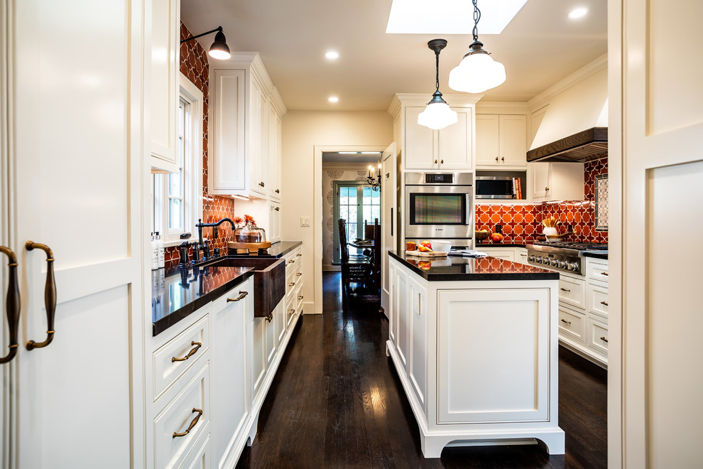 Mid-sized transitional u-shaped dark wood floor and brown floor enclosed kitchen photo in Los Angeles with an undermount sink, shaker cabinets, white cabinets, laminate countertops, multicolored backsplash, mosaic tile backsplash, stainless steel appliances, an island and brown countertops