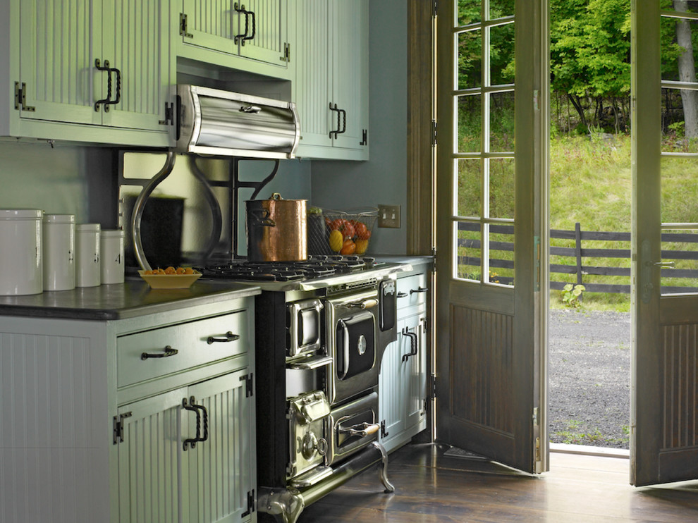 Immagine di una cucina parallela chic di medie dimensioni con ante con riquadro incassato, ante verdi, elettrodomestici neri, lavello stile country e parquet scuro