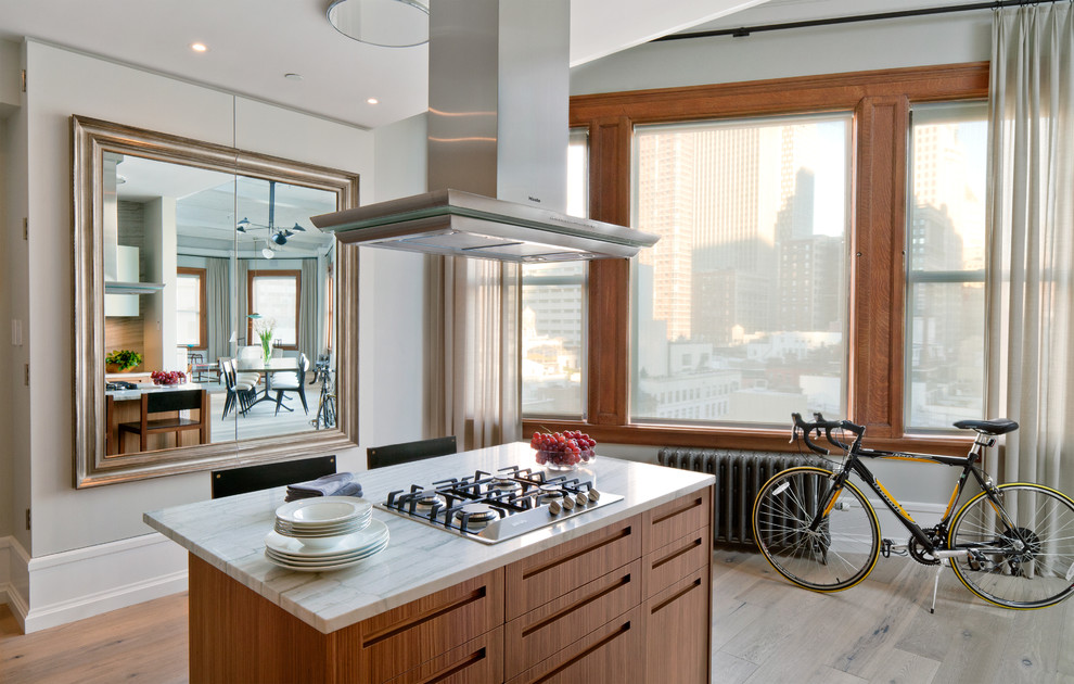ニューヨークにあるコンテンポラリースタイルのおしゃれなキッチン (中間色木目調キャビネット、フラットパネル扉のキャビネット、大理石カウンター、シルバーの調理設備) の写真
