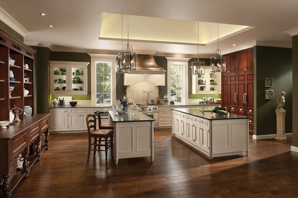 Photo of a country l-shaped kitchen in New York with beaded cabinets, white cabinets, grey splashback, stainless steel appliances, dark hardwood flooring and multiple islands.