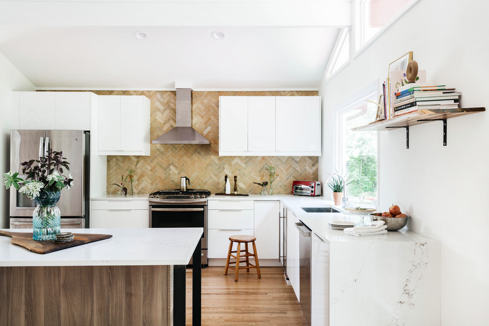 Foto di una cucina moderna con lavello sottopiano, ante lisce, ante bianche, paraspruzzi multicolore, elettrodomestici in acciaio inossidabile, pavimento in legno massello medio e top bianco