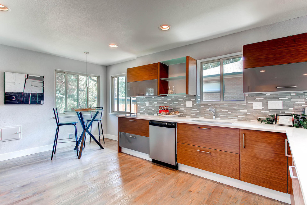 Inspiration for a mid-sized 1960s l-shaped medium tone wood floor eat-in kitchen remodel in Denver with an undermount sink, flat-panel cabinets, medium tone wood cabinets, quartz countertops, gray backsplash, metal backsplash and stainless steel appliances
